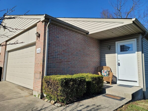 A single-story house with a garage, a front door, and a small porch with a chair. - Overbrook Delight -tranquil stay for day and night (Monroe)