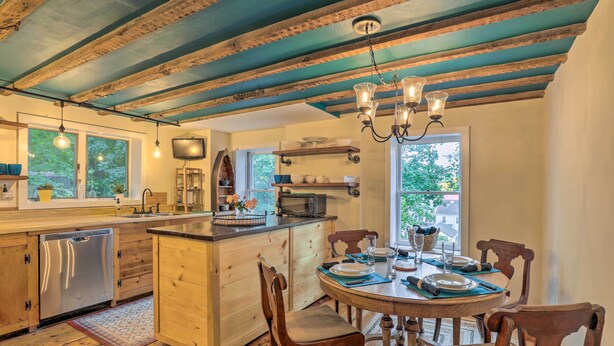 Una cocina con armarios de madera, una isla central y una mesa de comedor para cuatro.