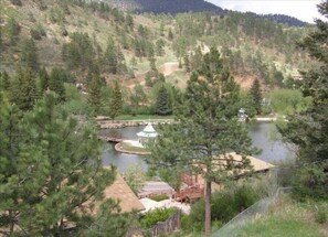 Vista su un lago con un gazebo, un pontile di legno e un piccolo ponte.