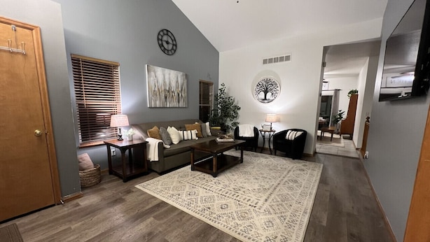 A living room with a sofa, coffee table, and a patterned rug. - Spacious 6-BDR Near USAFA with Mountain Views *Pet Friendly* (Colorado Springs)