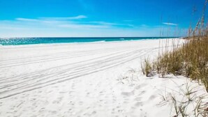 Une plage de sable blanc bordée d’une eau d’un bleu cristallin.