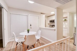 A modern kitchen with white cabinets, a microwave, and a sink.