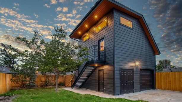A modern two-story house with a dark exterior, a visible staircase, and a garage. - Private guest house, king bed, work-from-home friendly, fully equipped kitchen (Denver)