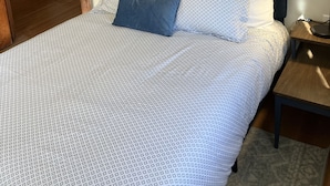 A bedroom with a bed, two framed pictures on the wall, a nightstand, and a lamp. - Charming & convenient house in downtown Marshall (Marshall)