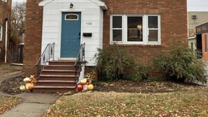 A two-story brick house with a blue front door, numbered 106, and a small porch with steps. - Charming & convenient house in downtown Marshall (Marshall)