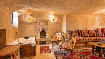 Un interior acogedor con una chimenea de piedra, un sofá con cojines de colores y un mueble de madera.