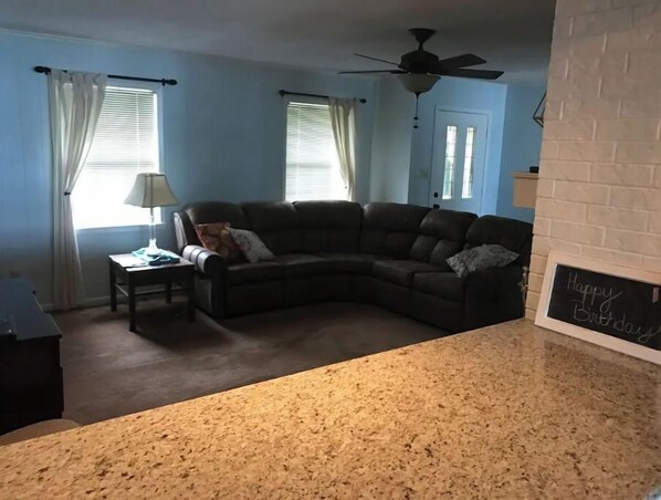 A living room with a sectional sofa, a coffee table, and a fireplace. - Lakehouse Getaway! (Pittsburg)