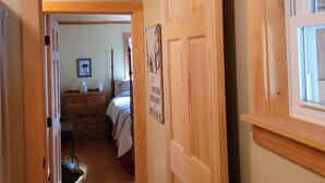 A wooden hallway with a door leading to a bedroom. A sign on the door reads "Winter Holiday in Abingdon, MA." - White mountain getaway (Carroll)