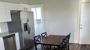 A kitchen with a dining table and chairs, a refrigerator, and a dishwasher. - Bright and cozy 3 bedroom apartment in Chicopee with AC, WiFi. Enjoy your stay (Chicopee)