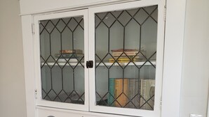 A white cabinet with two glass doors and a lower shelf with two drawers. - Bright and cozy 3 bedroom apartment in Chicopee with AC, WiFi. Enjoy your stay (Chicopee)