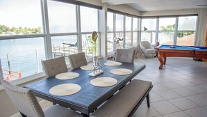 A dining area with a large table, chairs, and a pool table.