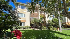 A multi-story hotel with a central courtyard, surrounded by lush greenery and palm trees. - Nice 2 bedroom Apt. in Ocean Dream (Cabarete)