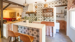 A modern kitchen with a central island, pendant lighting, and a star-patterned backsplash. - Finca Real de Niebla by Ruralidays (Huelva)