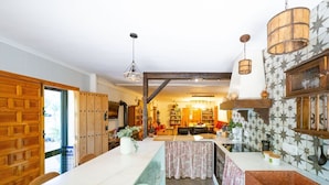 A spacious kitchen with a central island, wooden cabinets, and a patterned backsplash. - Finca Real de Niebla by Ruralidays (Huelva)