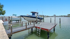 A dock with a boat, a wooden pier, and calm water. - Waterfront condo overlooking the gorgeous intracoastal, Perfect for large family/group...sleeps up to 12 with 2 kitchens!  Well behaved dogs welcomed.  Bring your boat! (Indian Rocks Beach)