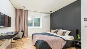 Ein modernes Schlafzimmer mit Bett, Schreibtisch und Stuhl.
