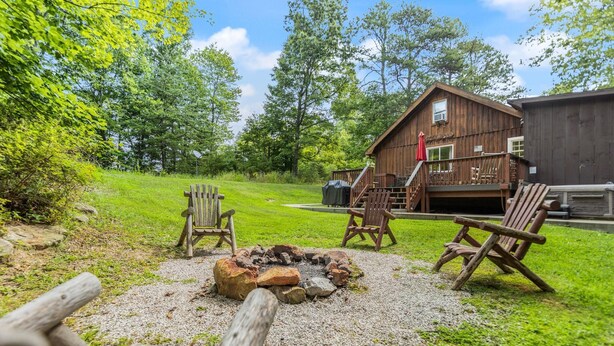 Eine rustikale Holzhütte mit Feuerstelle und Sitzgelegenheit im Freien.