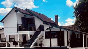Une maison à deux étages dotée d’une piscine, d’un patio couvert et d’un escalier menant à l’étage supérieur.