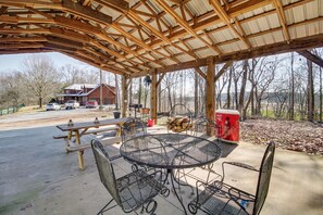 An outdoor covered picnic area with metal tables and chairs, a red cooler, and a wooden bench. - Calhoun Cabin w/ River View + Wraparound Deck (Calhoun)