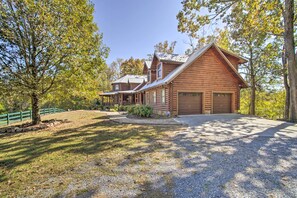 A log cabin with a large garage and a covered porch. - Calhoun Cabin w/ River View + Wraparound Deck (Calhoun)