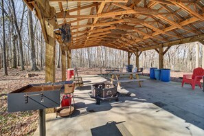 An outdoor covered area with a grill, a fire pit, picnic tables, and chairs. - Calhoun Cabin w/ River View + Wraparound Deck (Calhoun)
