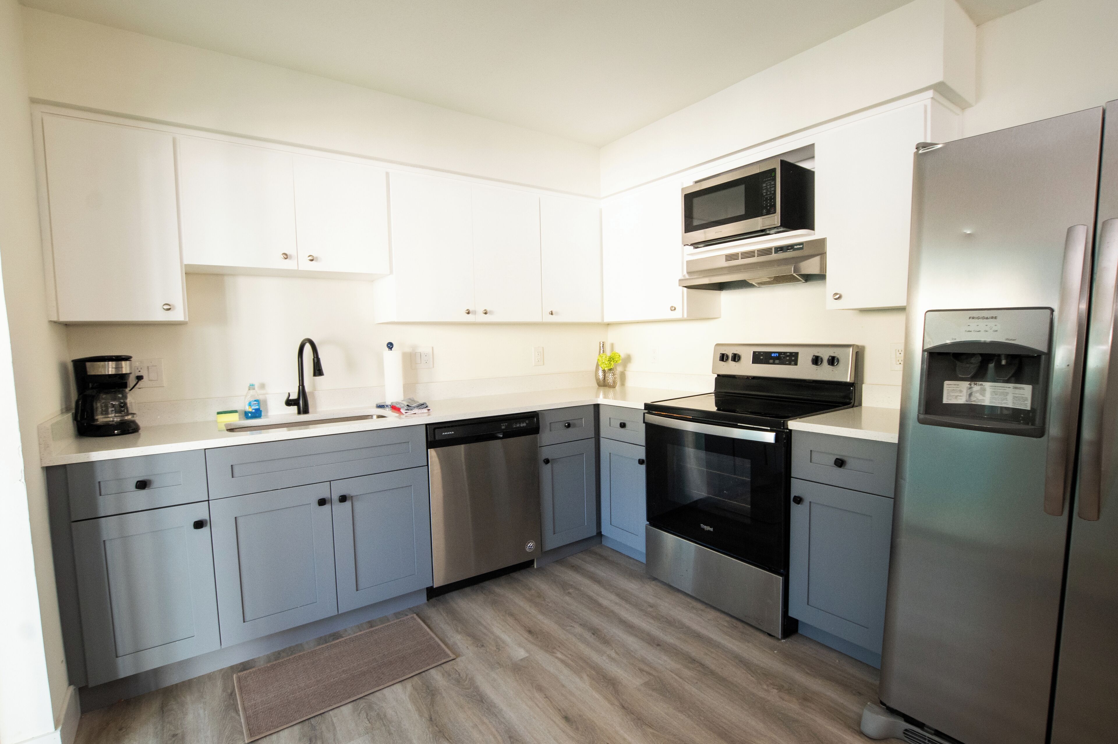 A modern kitchen with white cabinets, stainless steel appliances, and a dishwasher.