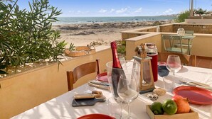 A table set for dining with a view of the beach.
