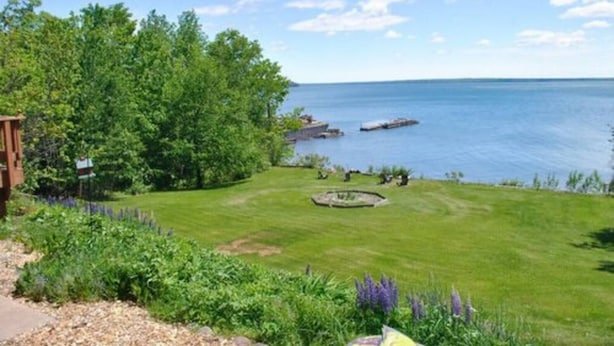 A grassy area with a pond and a wooden structure. - Bayfield Island View Lodging "Sevona Suite" on Lake Superior with Best Lake view (Bayfield)