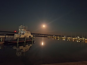 A marina at night with a ferry docked, calm water reflecting lights, and a clear view of the moon. - Bayfield Island View Lodging "Sevona Suite" on Lake Superior with Best Lake view (Bayfield)