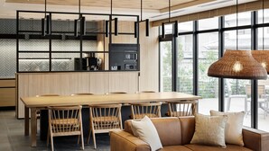 Una cocina moderna con una isla grande, armarios de madera y lámparas colgantes negras.