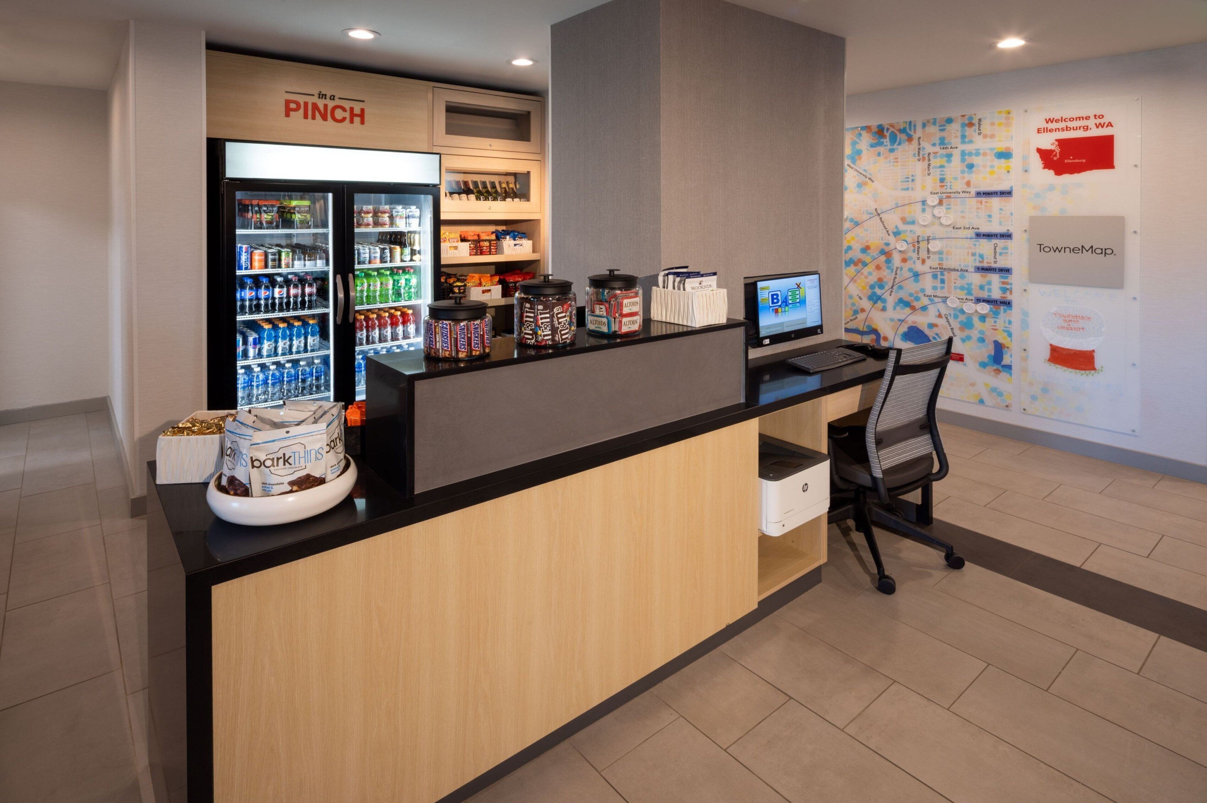 A reception area with a refrigerator labeled "PINCH," a computer, and a map on the wall.