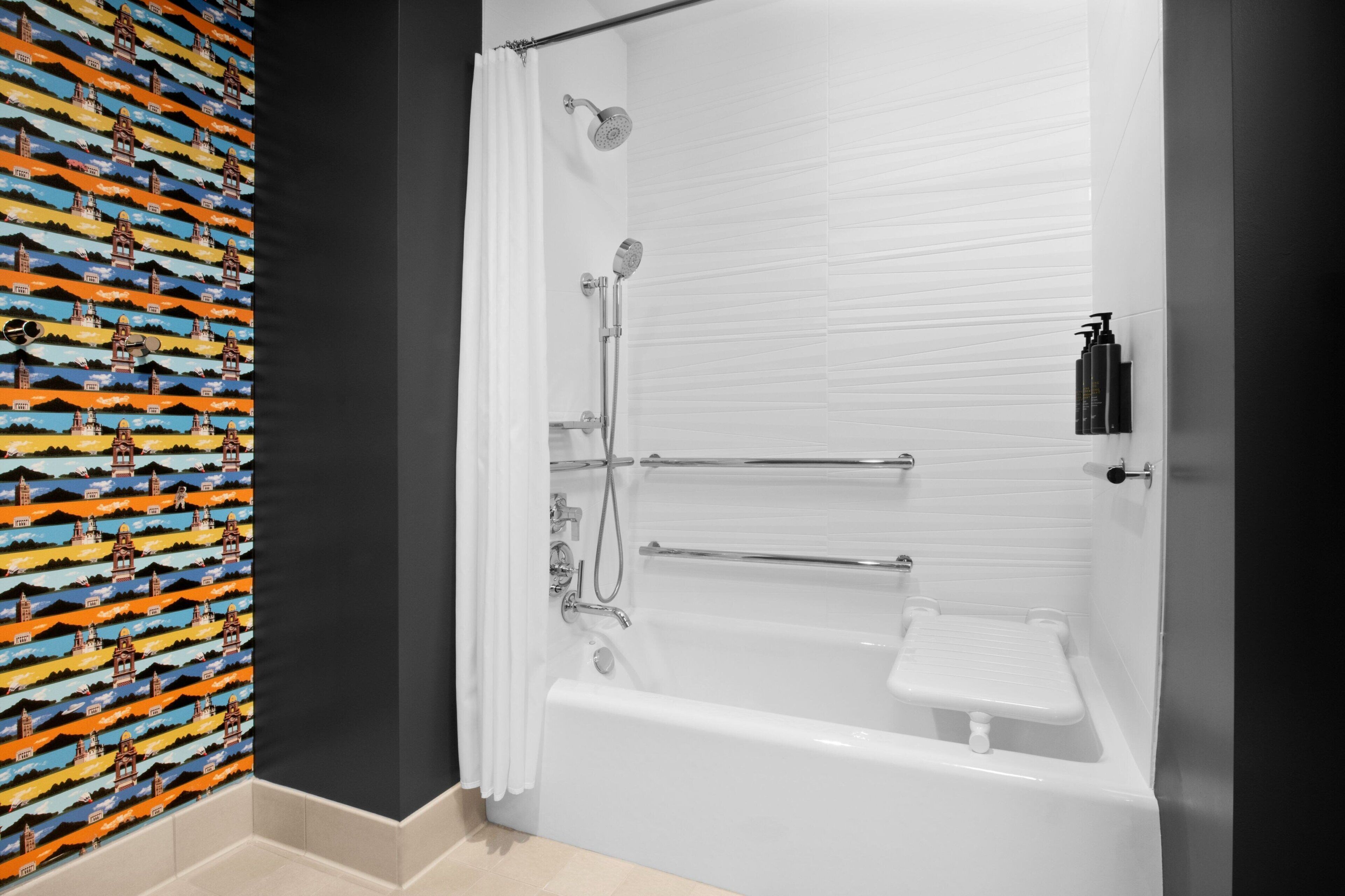 A modern bathroom with a bathtub, shower, and a towel rack.