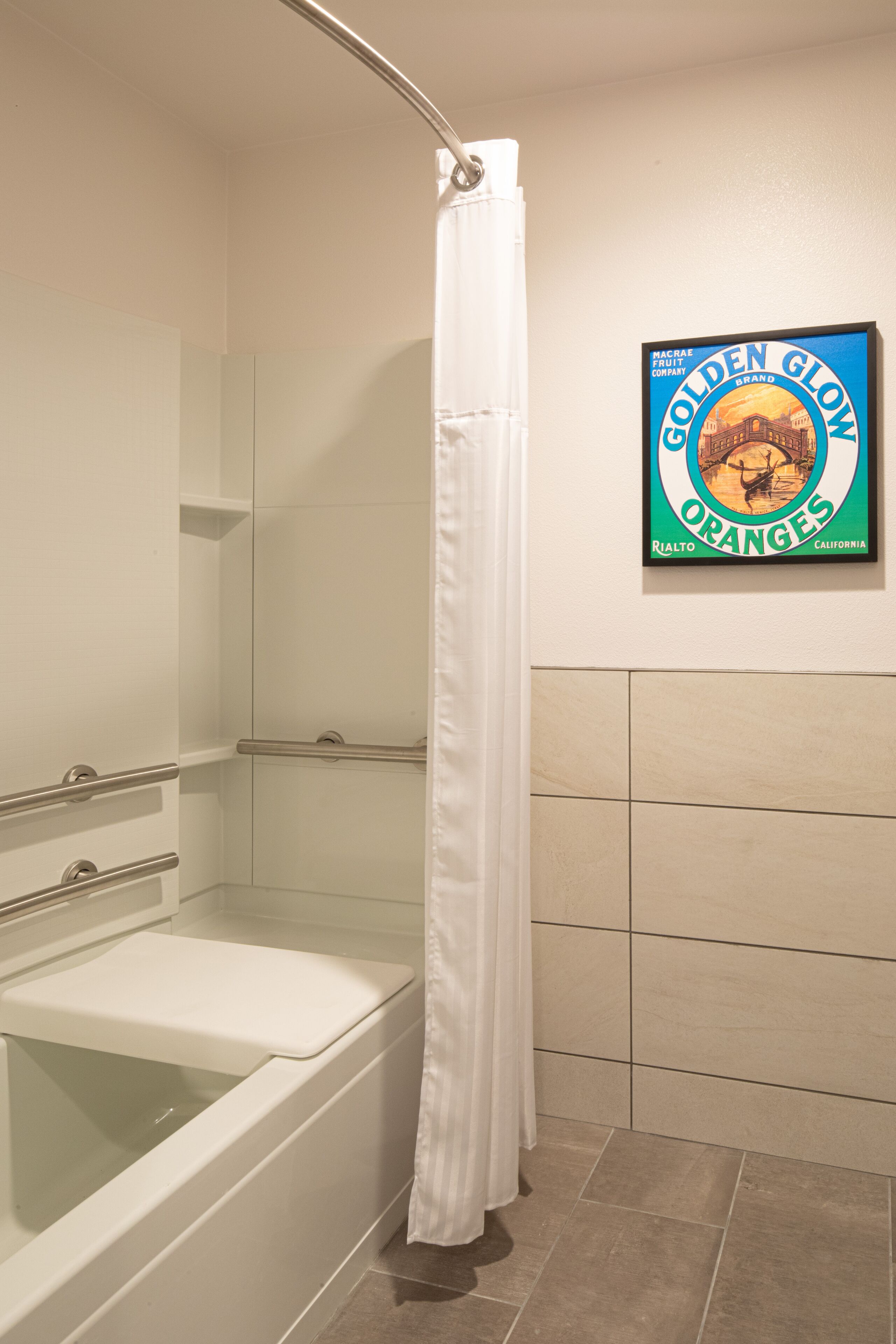 Un baño con bañera, cortina de ducha y un cartel en la pared que anuncia Naranjas Golden Glow.