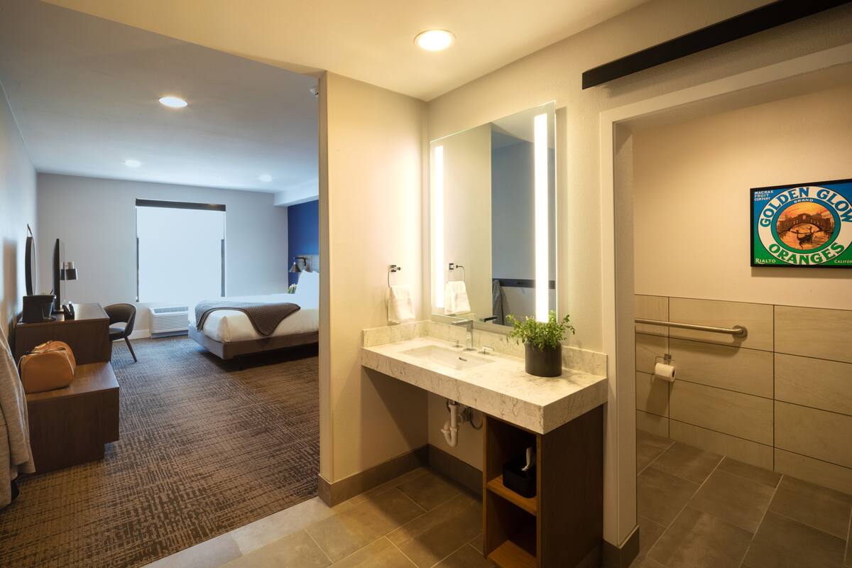 Ein modernes Hotelbad mit einem großen Spiegel, einem Waschbecken und einer Duschkabine.