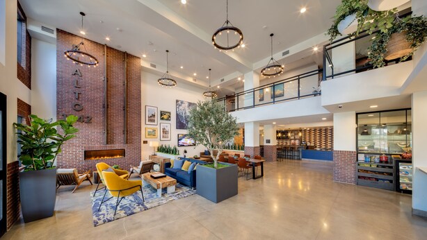 A spacious lobby with a fireplace, seating area, and a bar. - Ayres Hotel Rialto Fontana (Rialto)