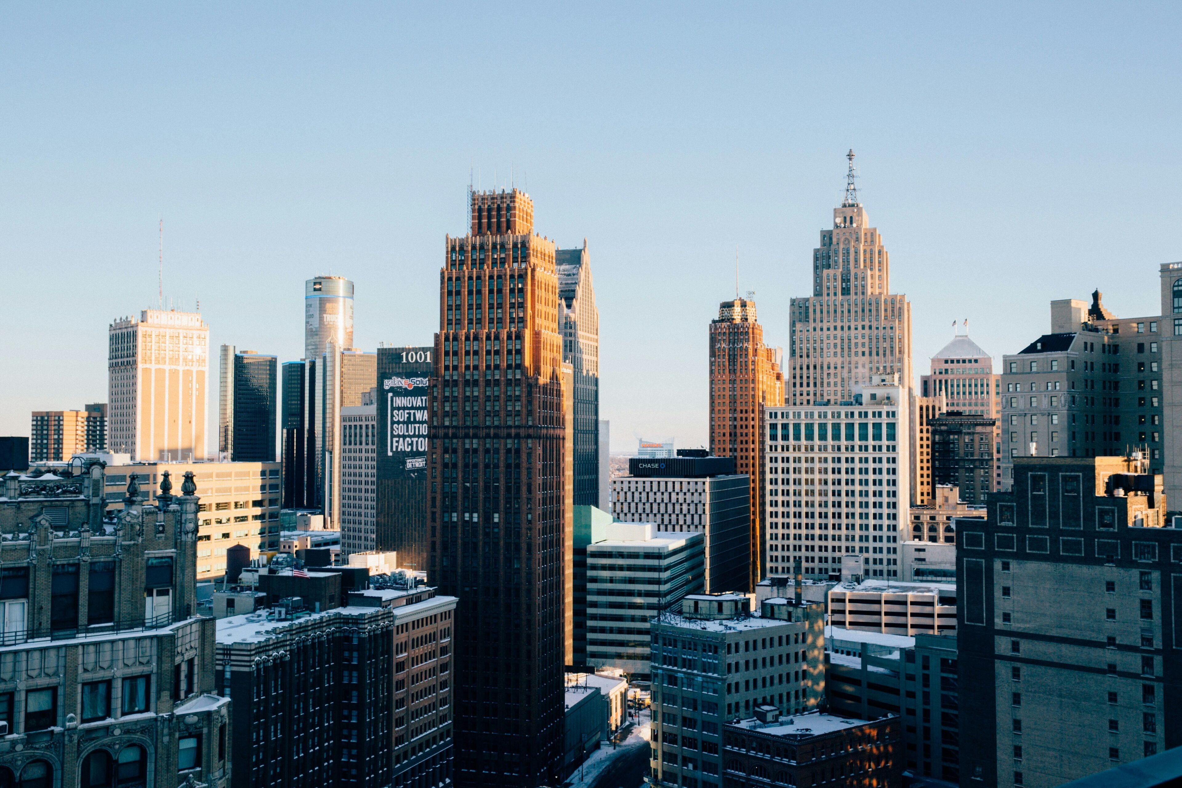 A cityscape with various buildings, including a prominent skyscraper with a unique facade and a building with a dome.
