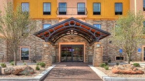 A hotel entrance with a stone facade, a covered entrance, and a wheelchair-accessible ramp. - King Studio Close to Texas Tech (Lubbock)