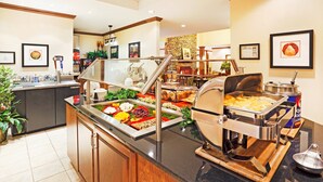 A buffet area with a variety of food options, a coffee station, and a seating area with a fireplace. - Studio | Free Breakfast. Indoor Pool & Gym. (Oak Ridge)