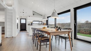 A modern kitchen with white cabinets, a central island, and pendant lighting. - 3 bedroom stunning home in Haderslev (Haderslev)