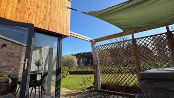 A wooden deck with a glass door leading to a patio area.