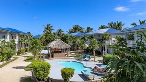 Ein Resort mit Pool, Liegestühlen und Palmen.