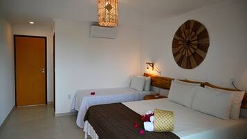 Habitación de hotel con dos camas, cabecero de madera, lámpara de pared y un adorno mural.