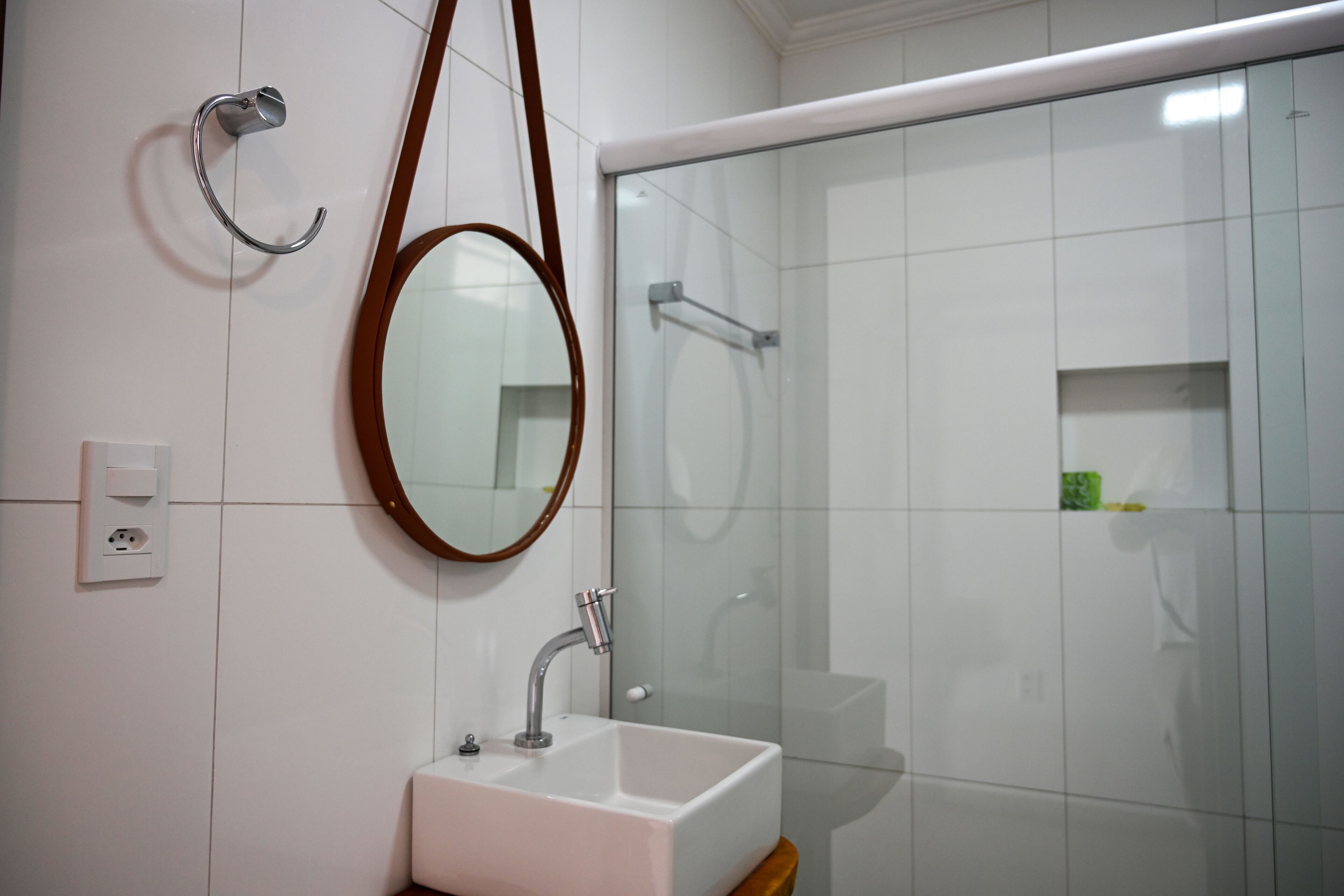 A bathroom with a white sink, a mirror, and a glass shower enclosure.