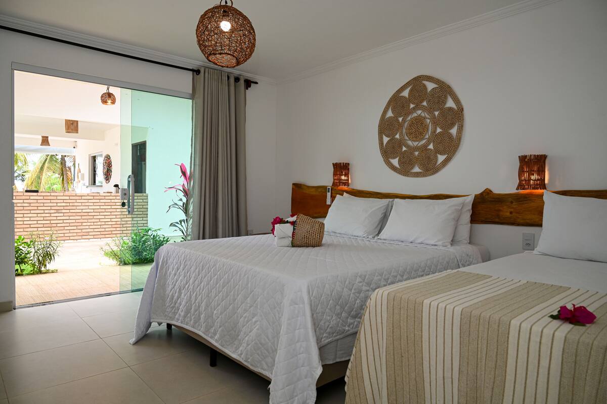 A hotel room with two beds, a large window, and a decorative wall hanging.