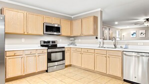Una cocina moderna con armarios de madera, electrodomésticos de acero inoxidable y lavavajillas.