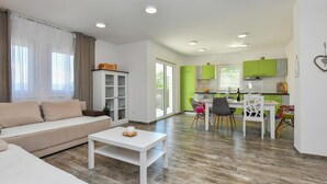 Un salon moderne comprenant un canapé, une table basse et un coin repas avec une table et des chaises.