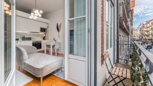 A modern apartment with a kitchen, dining area, and a balcony with a view of the street. - GuestReady - Amazing Studio in the heart of Porto (Porto)