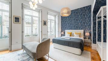 Tabla de planchar con plancha, internet y ropa de cama