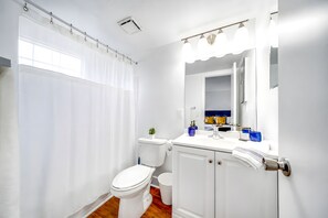 Ein modernes Badezimmer mit Toilette, Waschbecken und Spiegel.