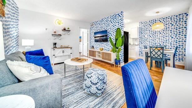 Una sala moderna con sofá, mesa de centro y comedor.